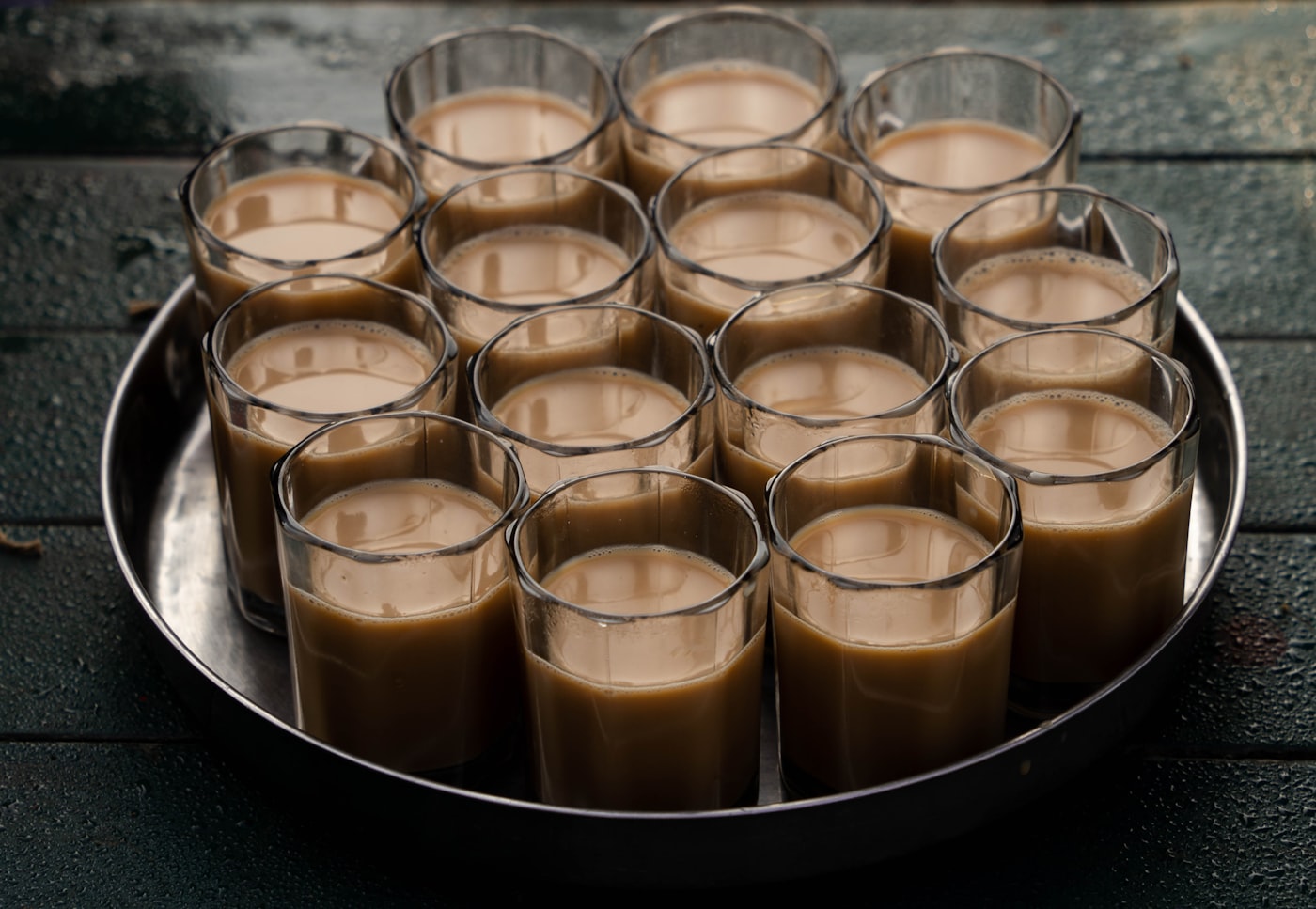 A steel tray of chai glasses